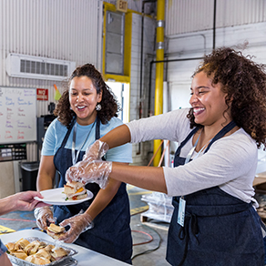 Two ladies feeding in a community food bank