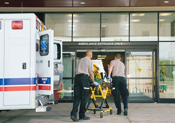 A young dad kicking a soccer ball with his son
